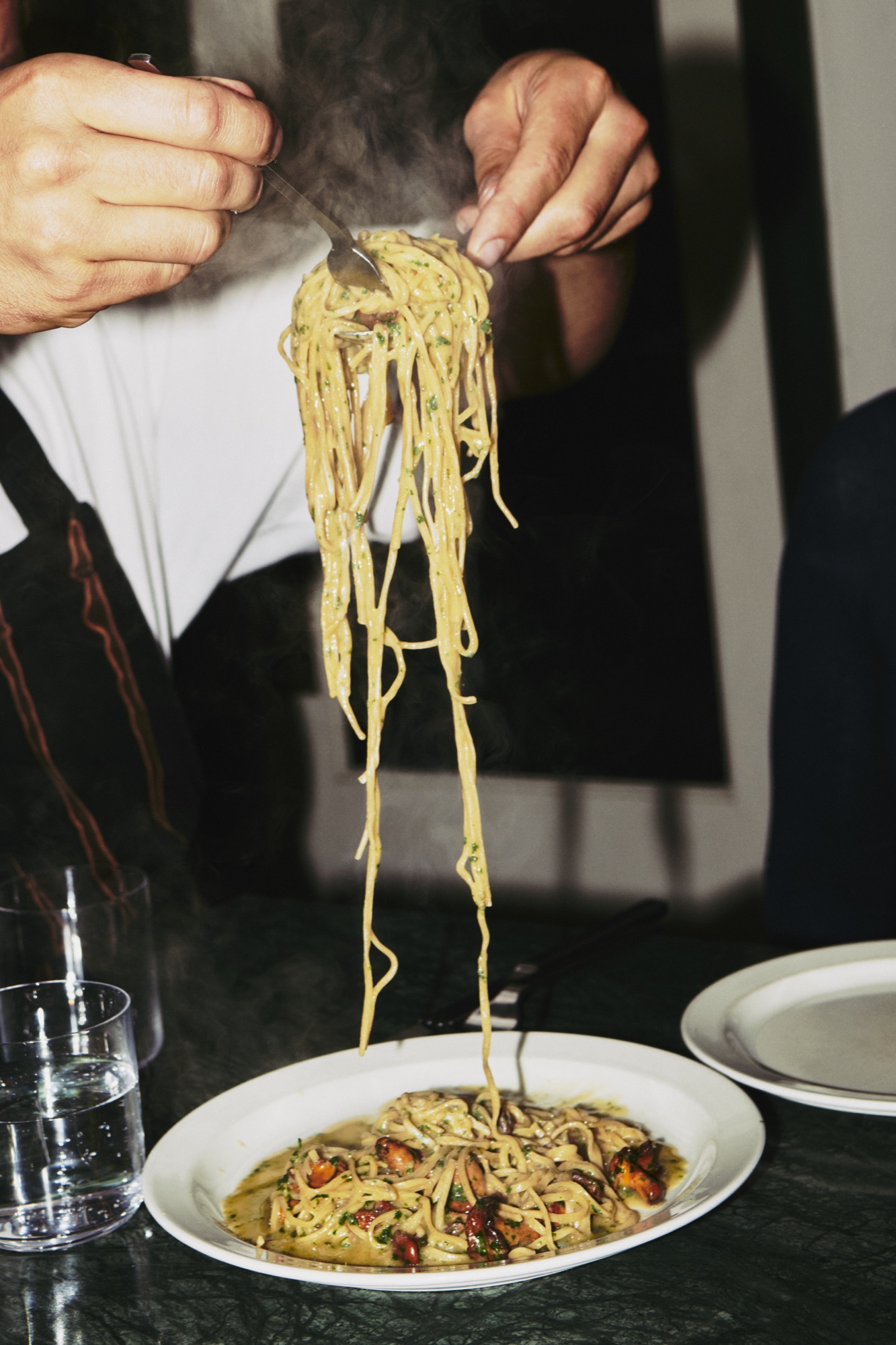 A steaming forkful of pasta lifted from the plate